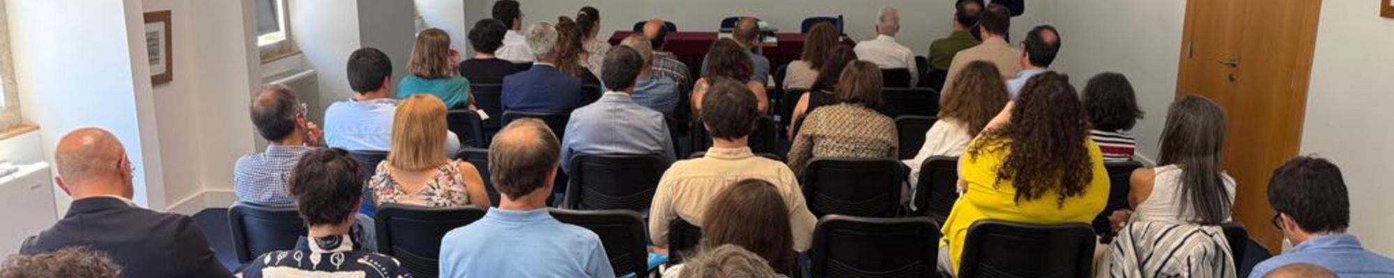 A room full of people sitting in front of a presentation screen